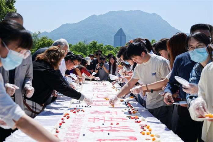 一群人在桌子前切蛋糕 AI 生成的内容可能不正确。